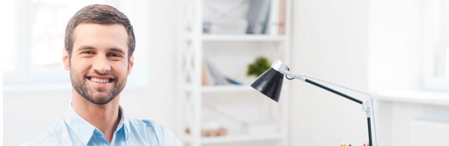 Ein Abteilungsleiter sitzt im Büro und lächelt