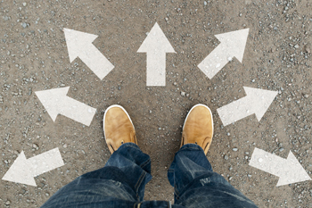 Ein Mann steht auf der Straße, er ist umgeben von Pfeilen, die in verschiedene Richtungen zeigen