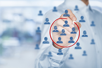 Person kreist mit Rotstift kleine Köpfe ein