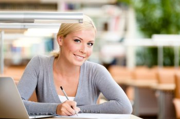 Eine Personalkoordinatorin sitzt am Laptop und schreibt etwas 