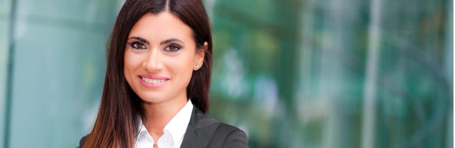 Eine Geschäftsfrau im Anzug lächelt in die Kamera