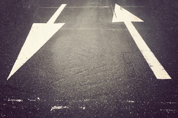 Eine Straße mit zwei weißen Pfeilen, die in unterschiedliche Richtungen zeigen