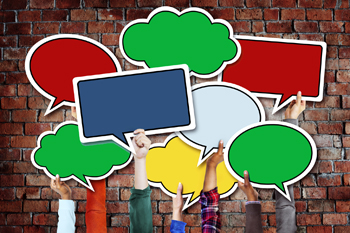 Hänte halten bunte ausgeschnittene Karten in Form von Sprechblasen hoch