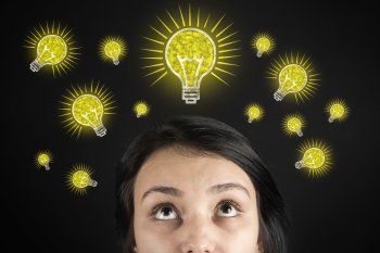 Frau sieht nach oben, leuchtende Glühbirnen über ihr