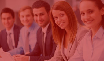 Geschäftsleute sitzen am Tisch und schauen in die Kamera