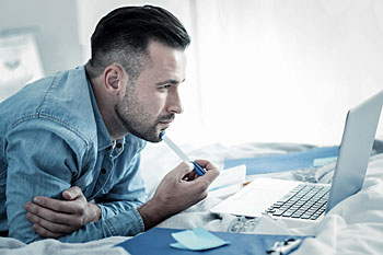 Mann arbeitet am Laptop.